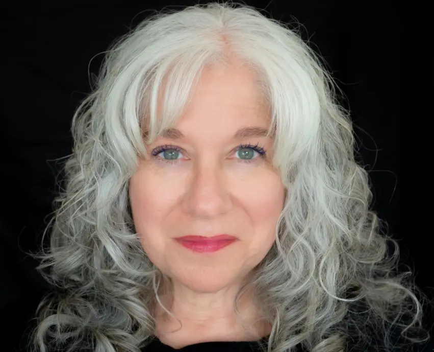 Smiling woman with curly gray hair
